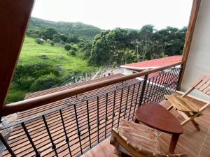 a balcony with a table and a chair and a view at VERONA Cabañas in Samaipata
