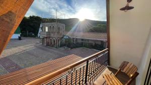 a balcony with a view of a church and the sun at VERONA Cabañas in Samaipata