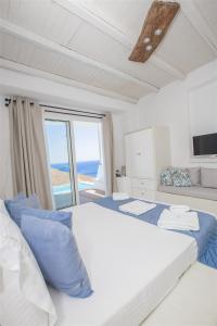 a bedroom with a large bed with a view of the ocean at Tholaria Boutique Hotel in Astypalaia Town