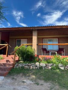 a house with a rock garden in front of it at Cabañas Vicentico in Mina Clavero