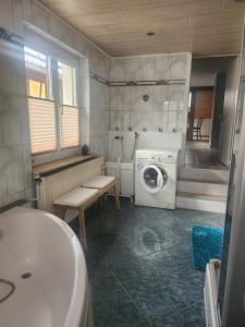 a bathroom with a washing machine and a sink at Ferienwohnung Silchmüller in Zella-Mehlis