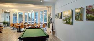 a room with a ping pong table and some paintings at Merry Mary in Marysville