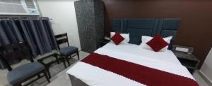 a bedroom with a large bed with red pillows at EVERGREEN Inn in Nalmatha