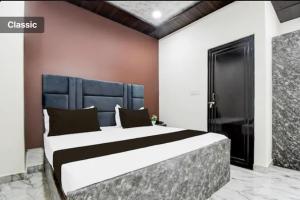 a bedroom with a large bed with a blue headboard at EVERGREEN Inn in Nalmatha