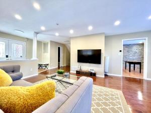 a living room with a couch and a flat screen tv at Paris Charm Modern 4B3B, Kitchen, Parking,5G in Richmond Hill