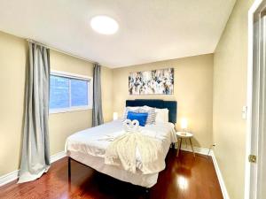 a bedroom with a large bed with blue pillows at Paris Charm Modern 4B3B, Kitchen, Parking,5G in Richmond Hill
