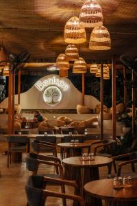 a restaurant with tables and chairs and chandeliers at The Benison in Ahangama