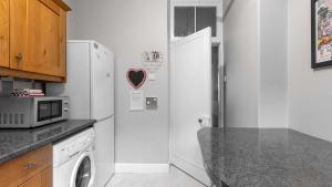 a kitchen with a refrigerator and a microwave at Govandale Seaviews in Kingarth +2 photos