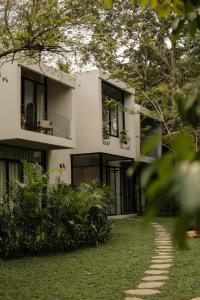 a white house with black windows and a yard at The Benison in Ahangama
