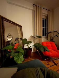 a living room with a red couch and a mirror at L'Atelier Saint Michel in Bordeaux