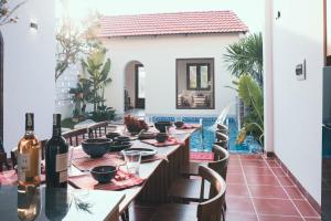 a dining room with a table with wine bottles at Mộc An Homestay in Kon Rung (1)