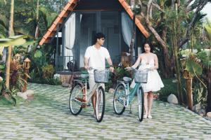 a man and a woman standing with their bikes at Mộc An Homestay in Kon Rung (1)