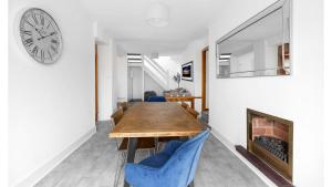 a dining room with a table and chairs and a clock at Craigend Cottage in Rothesay