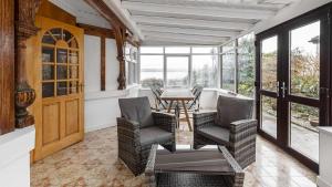 a room with chairs and a table and windows at Craigend Cottage in Rothesay