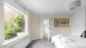 a bedroom with a bed and a large window at Craigend Cottage in Rothesay