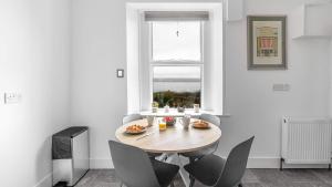 a dining room with a table and chairs and a window at Craigend Cottage in Rothesay