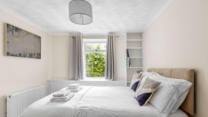 a white bedroom with a bed with a window at Craigend Cottage in Rothesay +8 photos