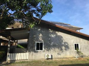 a gray building with a tree in front of it at Fahad Calm House in Ko Lanta