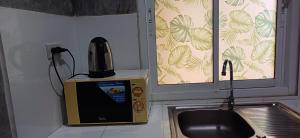 a microwave next to a sink in a kitchen at Fahad Calm House in Ko Lanta