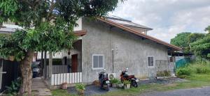 a house with two motorcycles parked in front of it at Fahad Calm House in Ko Lanta