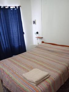 ein Schlafzimmer mit einem Bett und einem blauen Vorhang in der Unterkunft Cabañas Midelem in Chascomús + 19 Fotos