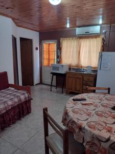 ein Zimmer mit einem Tisch und eine Küche mit einem Tisch und einem Tisch in der Unterkunft Cabañas Midelem in Chascomús