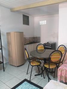 a kitchen with a table and chairs and a refrigerator at Kitnet para 4 pessoas in Triunfo