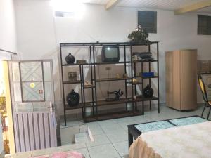 a living room with a tv on a shelf at Kitnet para 4 pessoas in Triunfo