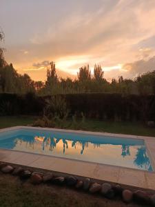 a swimming pool with the sunset in the background at Casa Darragueira de Chacras de Coria in Chacras de Coria