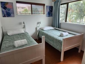 a bedroom with two beds and a window at Pleasant View Apartment - Ocean View in Caloundra