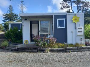 a blue tiny house with a flower on the window at Round About in Parore