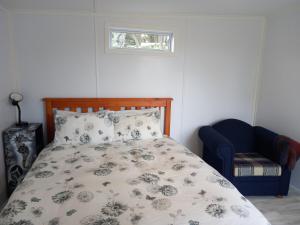 a bedroom with a bed and a chair and a window at Round About in Parore