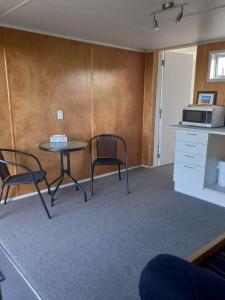 a room with a table and two chairs and a microwave at Round About in Parore +11 photos