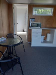 a small kitchen with a table and a microwave at Round About in Parore