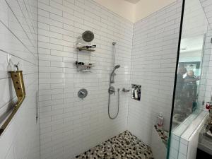 a white tiled bathroom with a shower with a glass door at Scenic Farmhouse in Riverton +36 photos