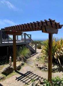 a wooden pergola in front of a house at Bodega Bay Magical Ocean Front w/Amazing View! in Bodega Bay