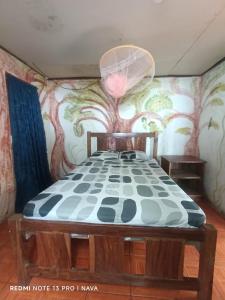 a bedroom with a bed with a painting on the wall at Hostal La Gloria in Mérida