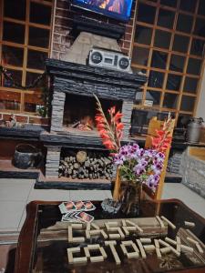 a living room with a fireplace and a table at Hostal Casa Cotopaxi in Latacunga