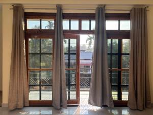 a large window with curtains in a room at Janaa Residence in Dithur