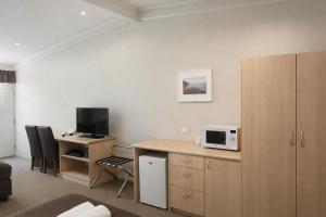 a room with a kitchen with a desk with a microwave at Highway One Motel in Ceduna