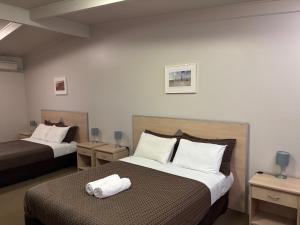 a hotel room with two beds with towels on the bed at Highway One Motel in Ceduna