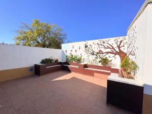 a patio with benches and flowers on a wall at Hospedaje La Gardenia in Zacatlán