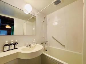 a bathroom with a sink and a shower and a mirror at Pension Shishikui in Shishikui +74 photos