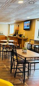 a restaurant with tables and chairs and a tv on the wall at Wingate by Wyndham Utica in Utica