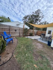 a backyard with a blue picnic table and a fence at The Corner Cottage in Palm Harbor