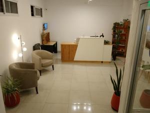 a living room with two chairs and a counter at Hotel Cristal in Viedma
