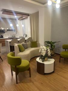 a living room with a couch and chairs and a table at Departamento de lujo inteligente in Cochabamba