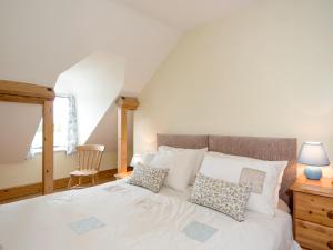 a bedroom with a large white bed with pillows at The Stable in Foxham +12 photos