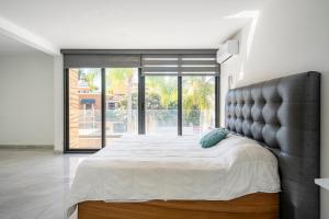 a bedroom with a large bed with a large window at Casa para 16 personas con alberca climatizada in Guadalajara +129 photos