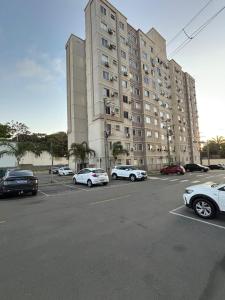 a large building with cars parked in a parking lot at Torres dos Holandeses Vista Mar in São Luís